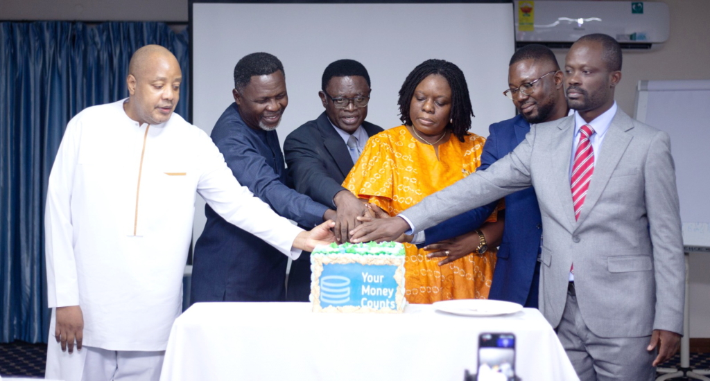 The YMC Ghana team cutting a cake at the launch