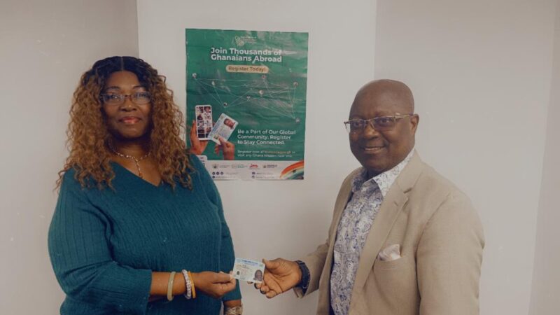 Prof. Kenneth Agyemang Attafuah (Right) presenting the card to a Ghanaian registered in New York in the USA