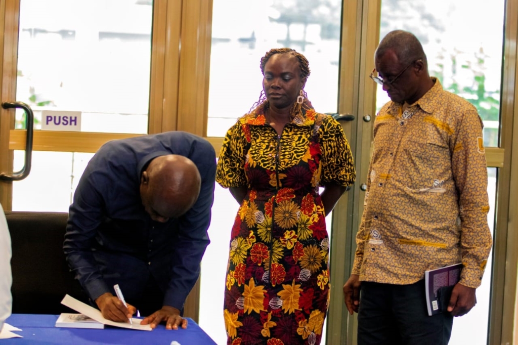 Professor Amartey autographing a copy of the book